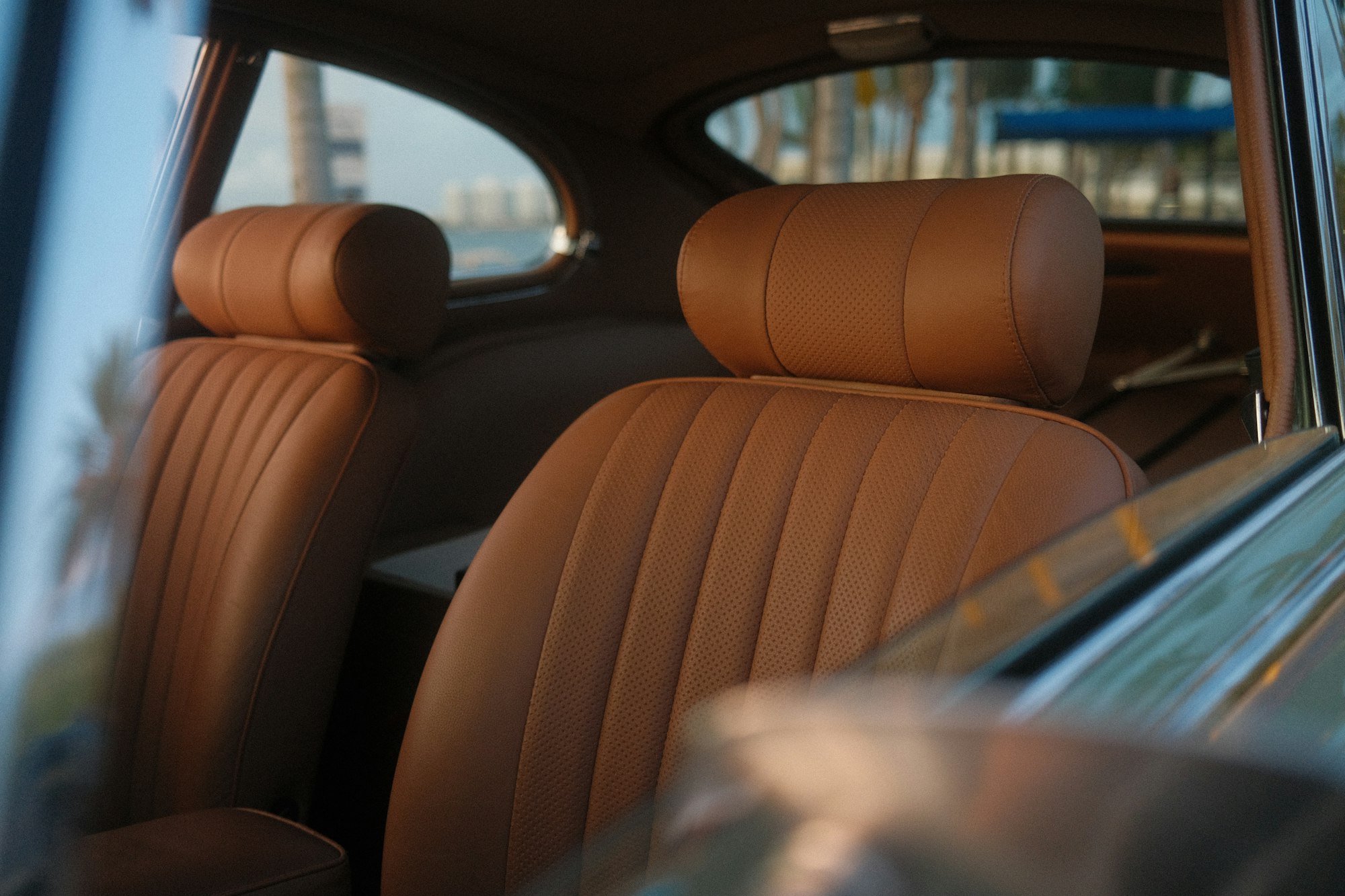 Tan perforated leather front seats seen through an open window