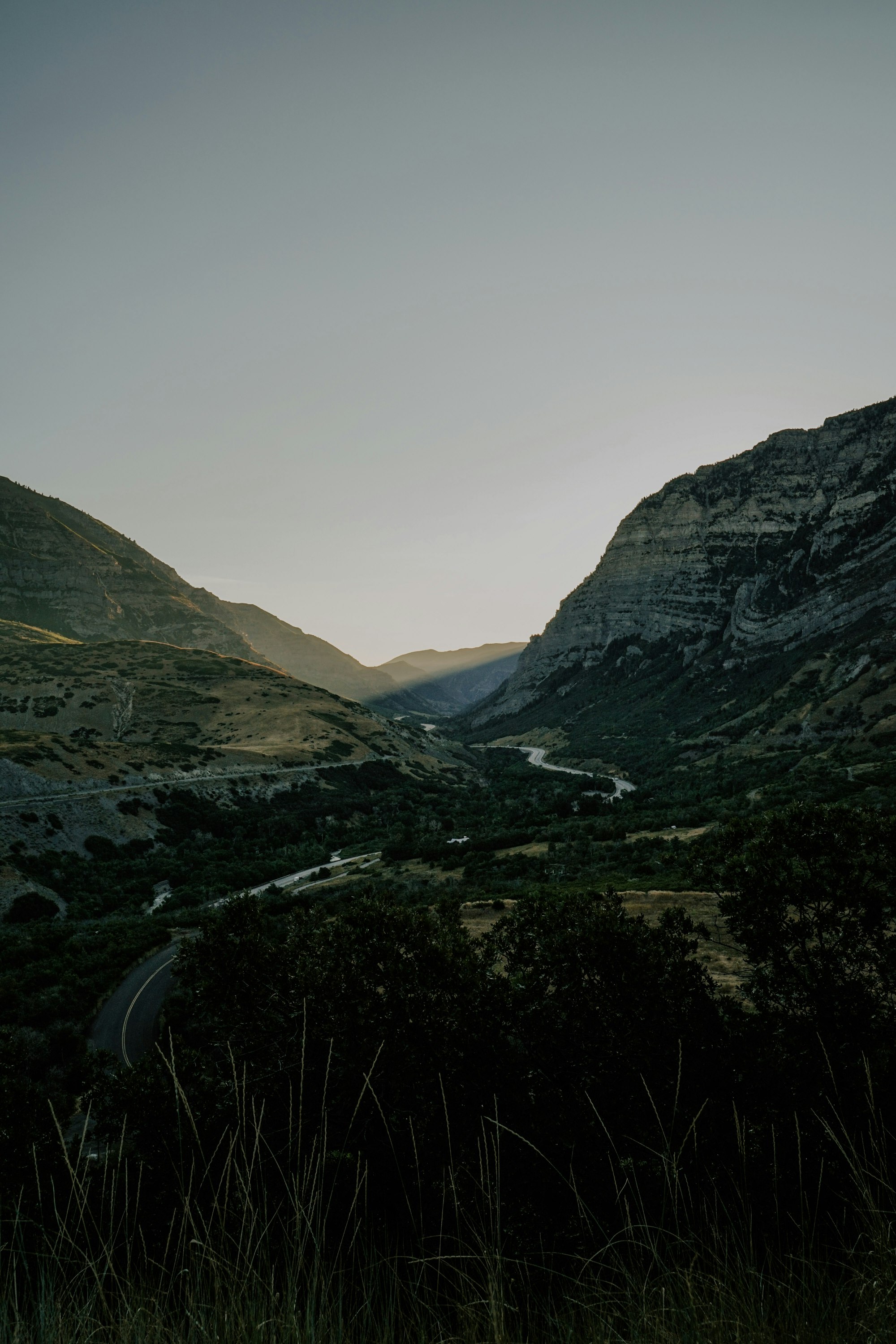A road winding through a mountain valley at dusk